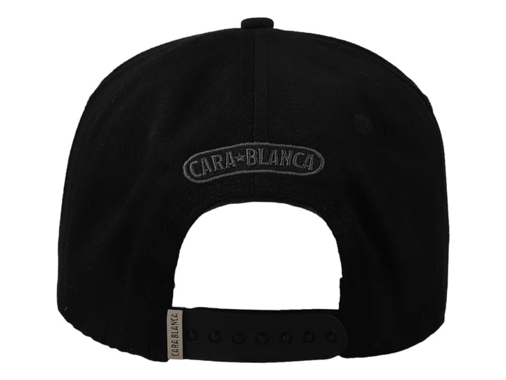 Gorra negra Cara Blanca con bordado gris de cuernos y letras CB, visera con borde verde y detalle lateral en cuero.