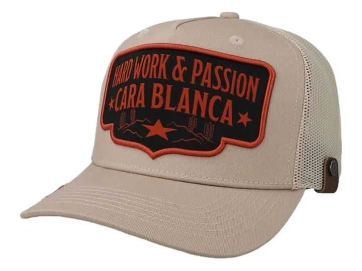 Gorra color crema marca Cara Blanca con parche frontal bordado en negro y naranja y parte trasera de malla.