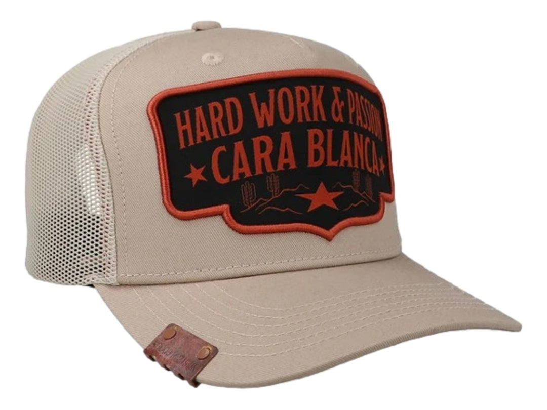 Gorra color crema marca Cara Blanca con parche frontal bordado en negro y naranja y parte trasera de malla.