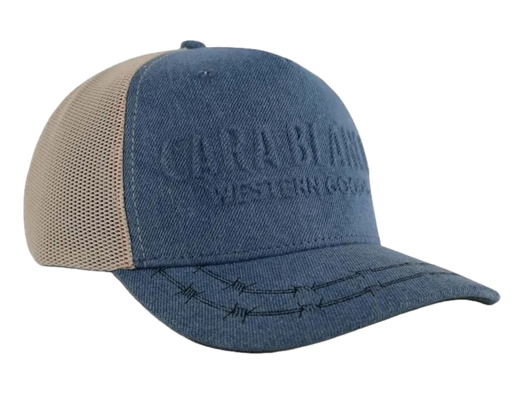 Gorra Cara Blanca de color denim con panel trasero de malla beige y bordado decorativo en la visera.
