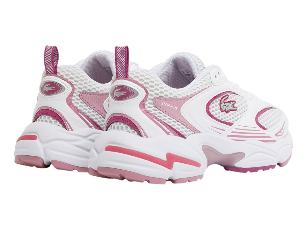 Tenis deportivos Lacoste blancos con detalles en morado claro y suela robusta.