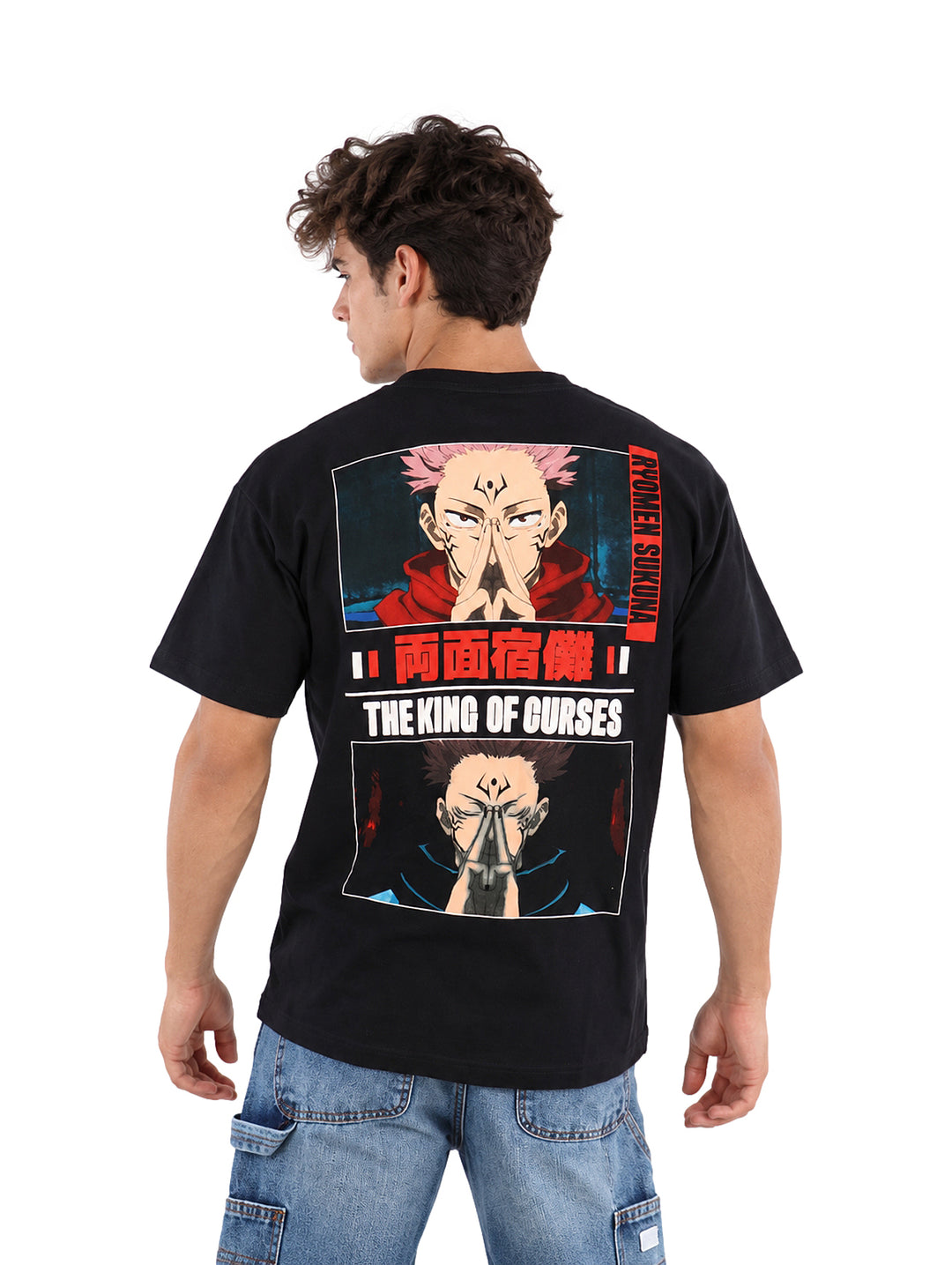 Hombre vistiendo playera negra de manga corta con letras rojas en el pecho y jeans azules.