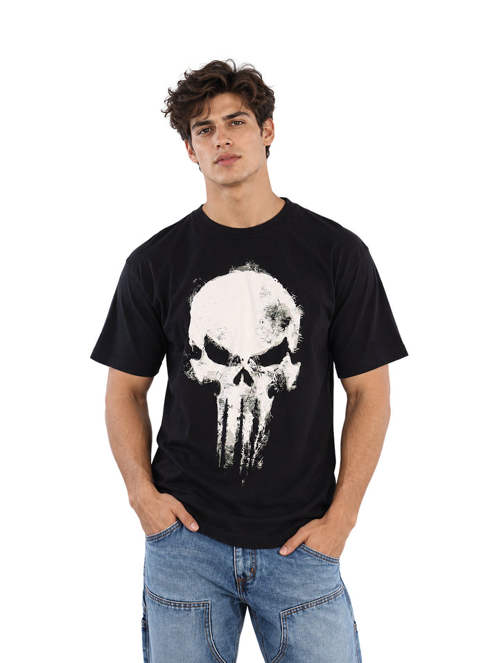 Hombre vistiendo playera negra de manga corta con estampado de calavera blanca en el pecho.