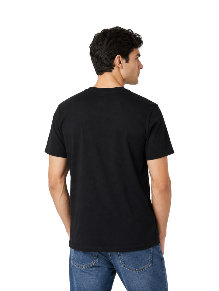 Hombre vistiendo playera negra de manga corta marca Calvin Klein con logo frontal.