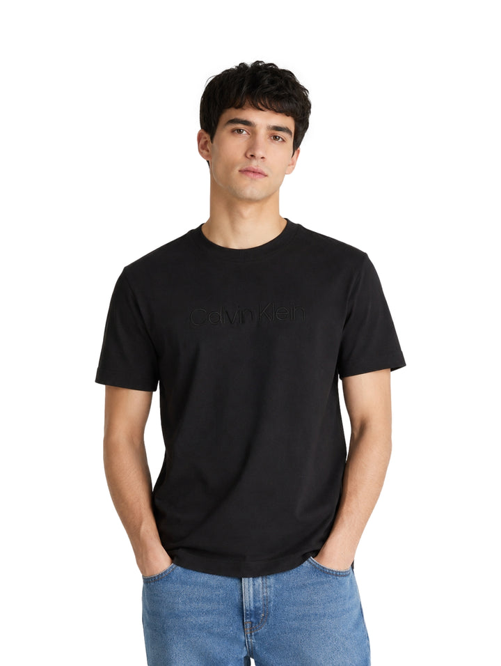 Hombre vistiendo playera Calvin Klein de color negro con cuello redondo y manga corta.
