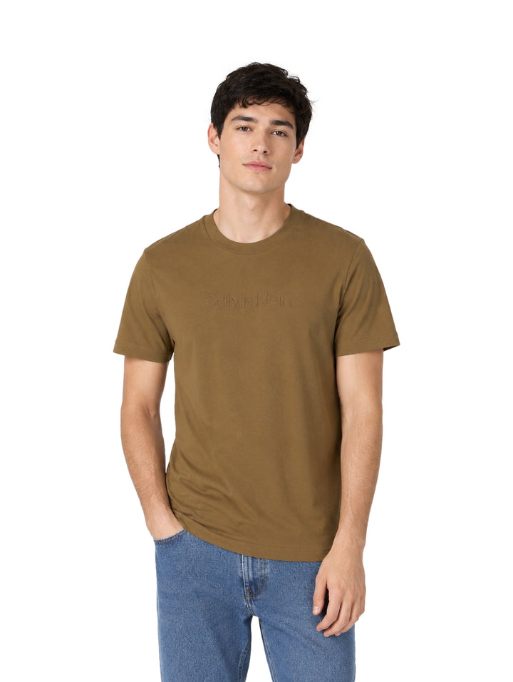 Hombre vistiendo playera Calvin Klein color capers de manga corta y cuello redondo.