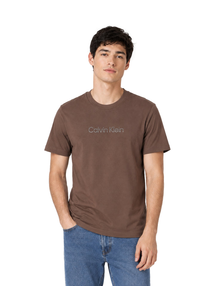 Hombre vistiendo una playera Calvin Klein de color marrón Warm Oak con cuello redondo y manga corta.