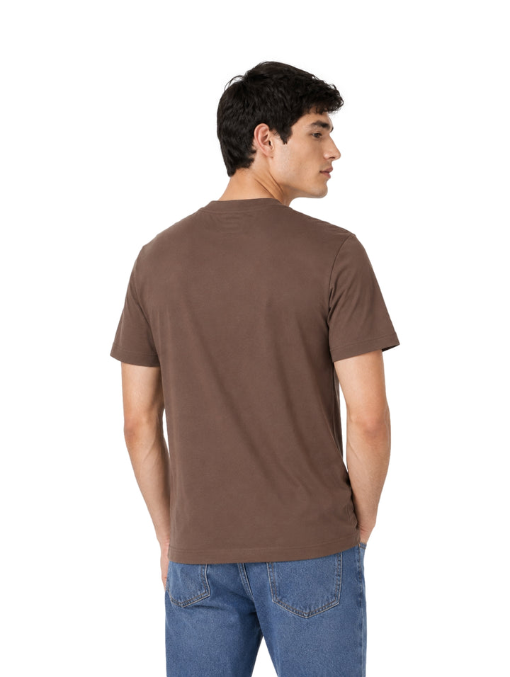 Hombre vistiendo una playera Calvin Klein de color marrón Warm Oak con cuello redondo y manga corta.