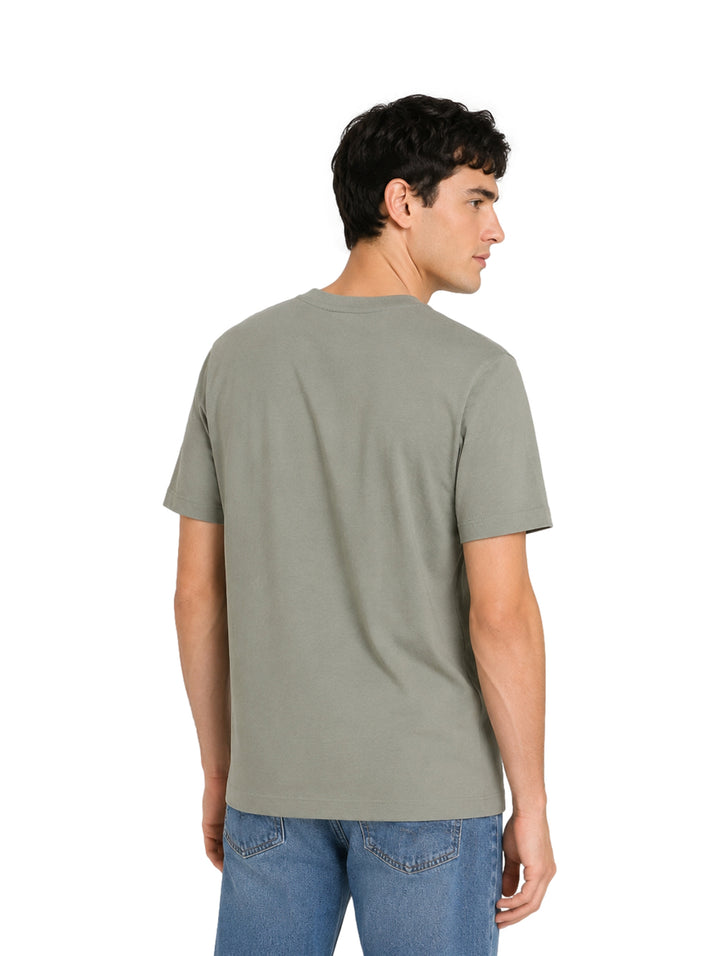 Hombre vistiendo playera Calvin Klein color shadow de manga corta y cuello redondo.