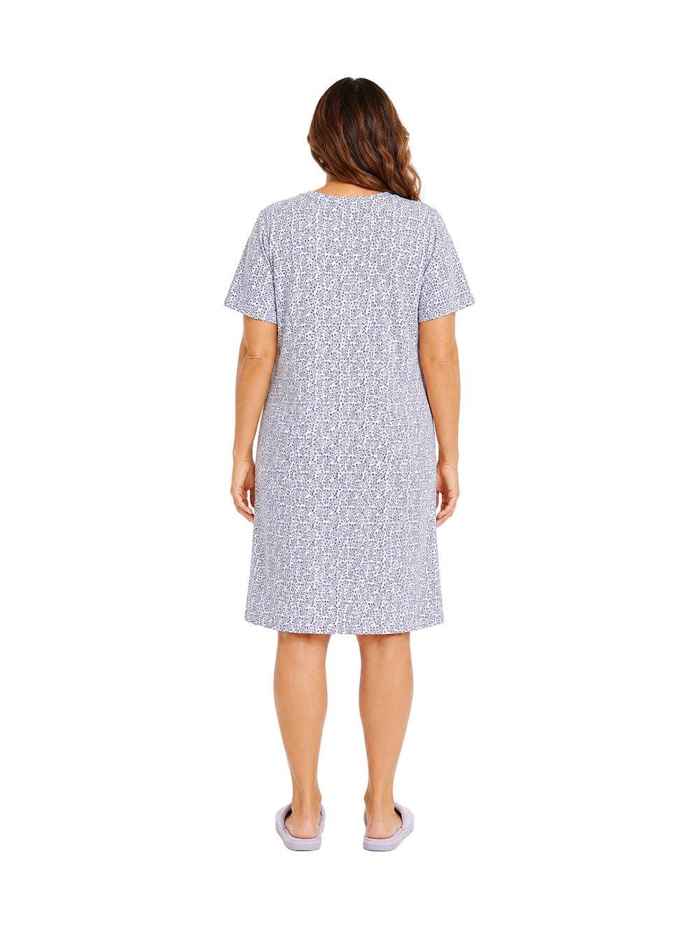 Mujer vistiendo bata pijama corta de color morado con estampado floral blanco.