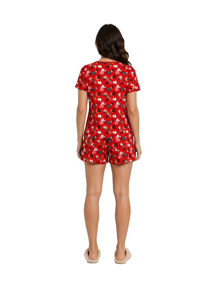 Mujer vistiendo pijama roja de dos piezas con estampado blanco, compuesta por camiseta de manga corta y short.