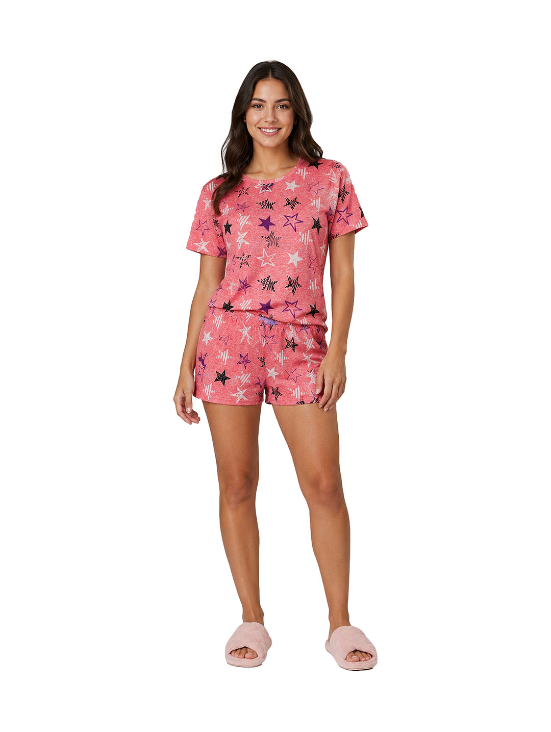 Mujer vistiendo pijama color coral de dos piezas con estampado de estrellas y pantuflas rosas.
