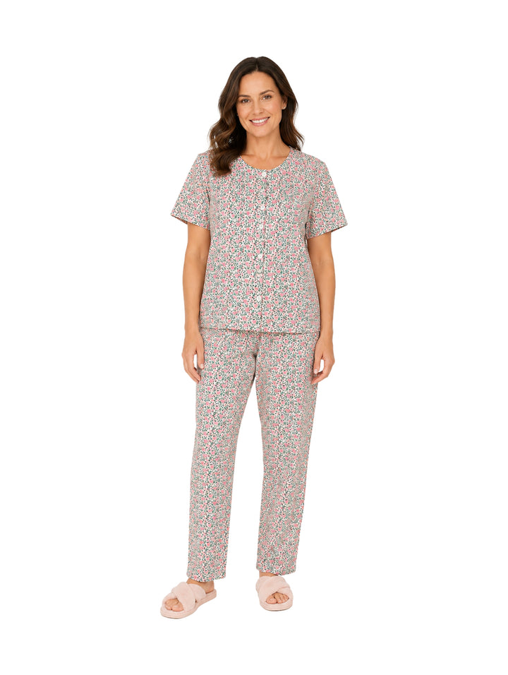 Mujer vistiendo pijama de dos piezas color rosa con estampado floral.