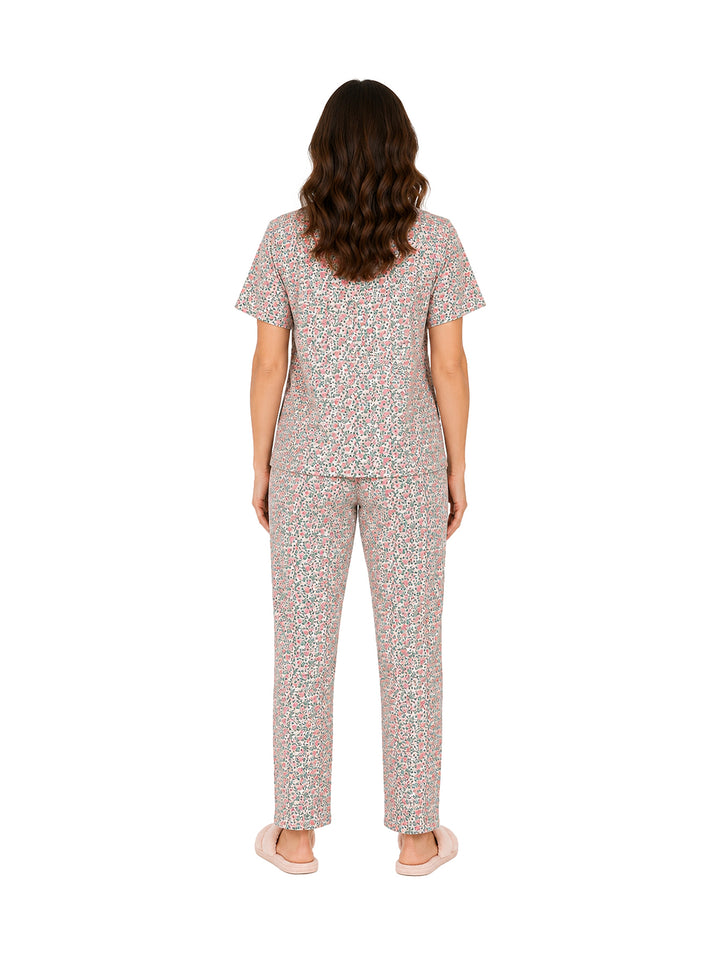 Mujer vistiendo pijama de dos piezas color rosa con estampado floral.