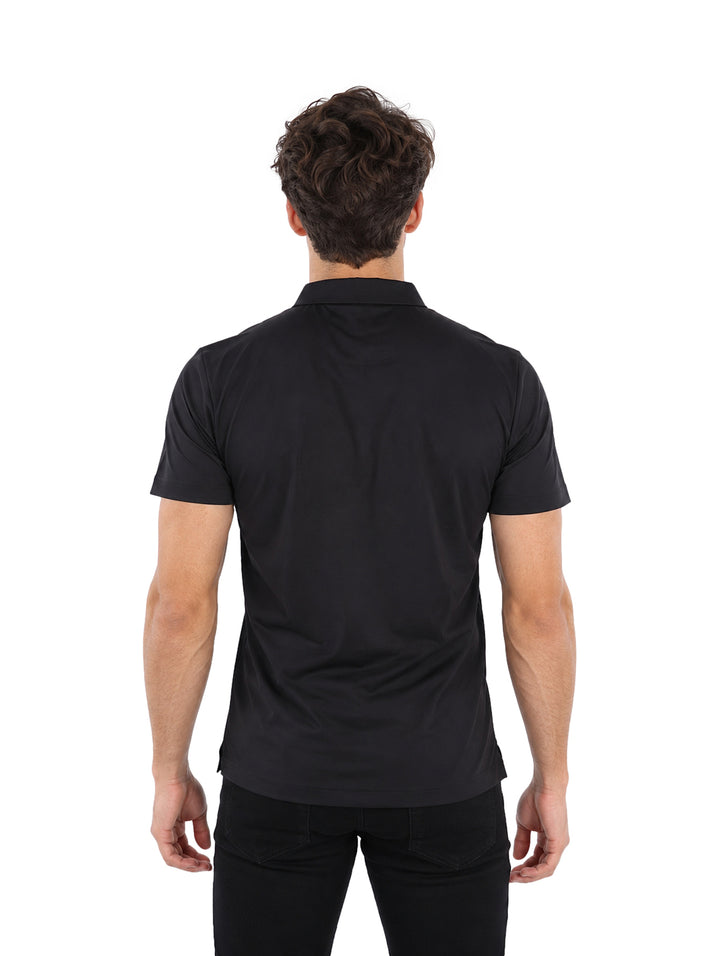 Hombre vistiendo playera polo Pavini color negro con detalle lineal gris en el pecho.