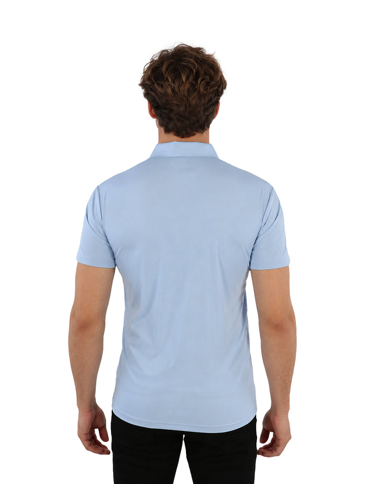 Hombre vistiendo playera polo azul claro y pantalones negros.