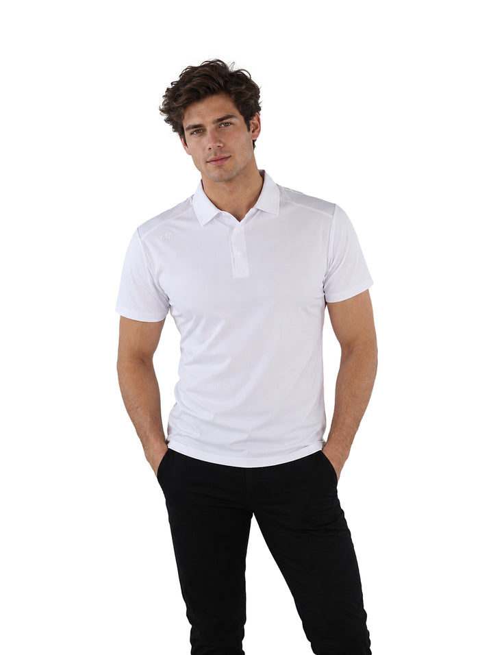 Hombre vistiendo una playera polo blanca de manga corta y pantalones negros sobre fondo blanco.
