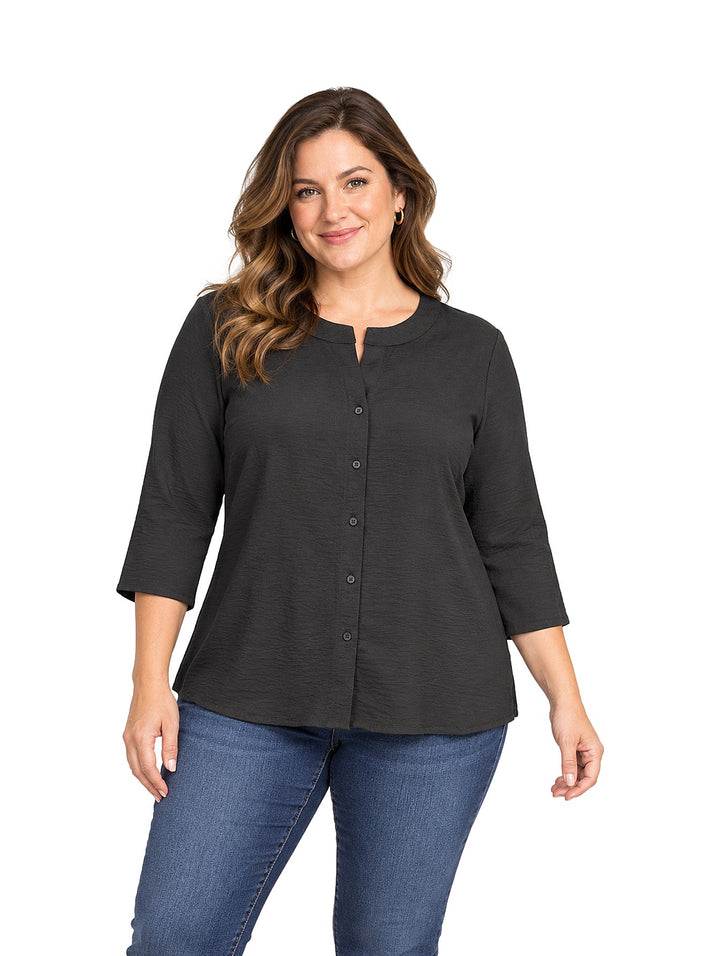 Mujer vistiendo una camisa negra de manga tres cuartos con botones frontales y jeans azules.