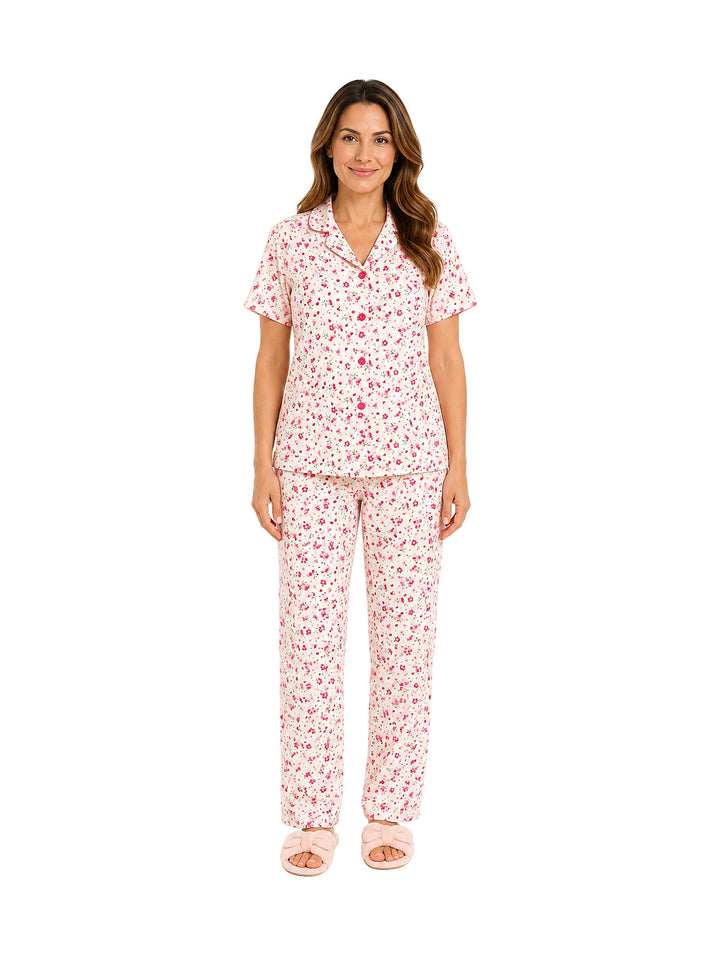 Mujer vistiendo pijama de dos piezas color rosa con estampado floral.