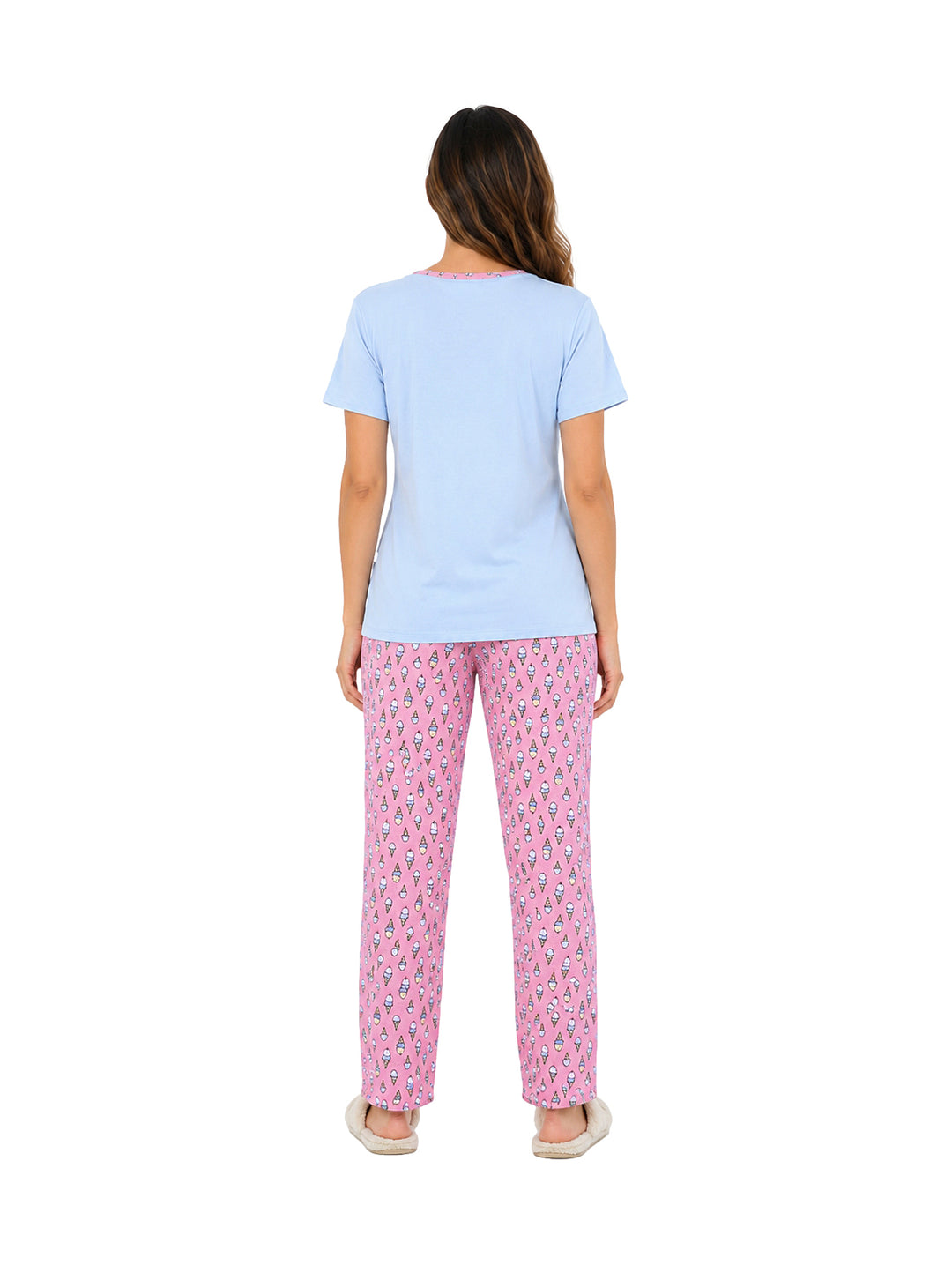 Mujer vistiendo pijama de dos piezas con camiseta color cielo y pantalón rosa estampado.