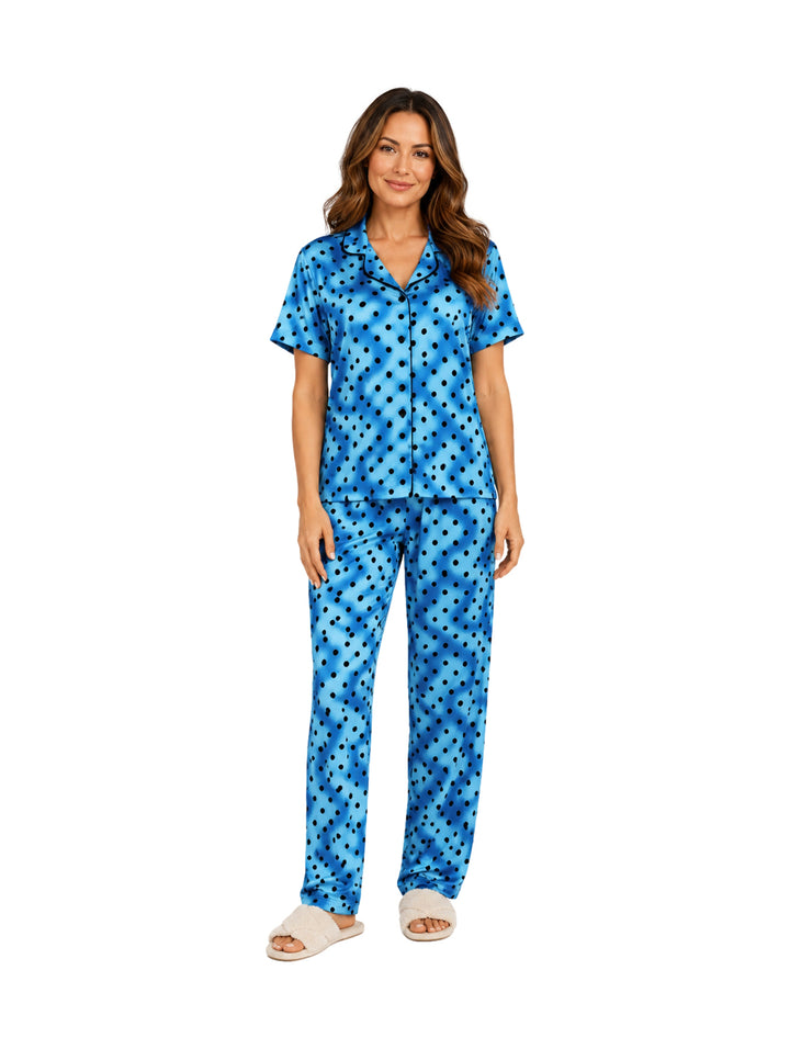 Mujer vistiendo pijama azul de dos piezas con estampado de lunares oscuros.