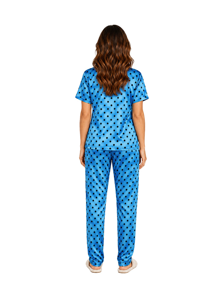 Mujer vistiendo pijama azul de dos piezas con estampado de lunares oscuros.