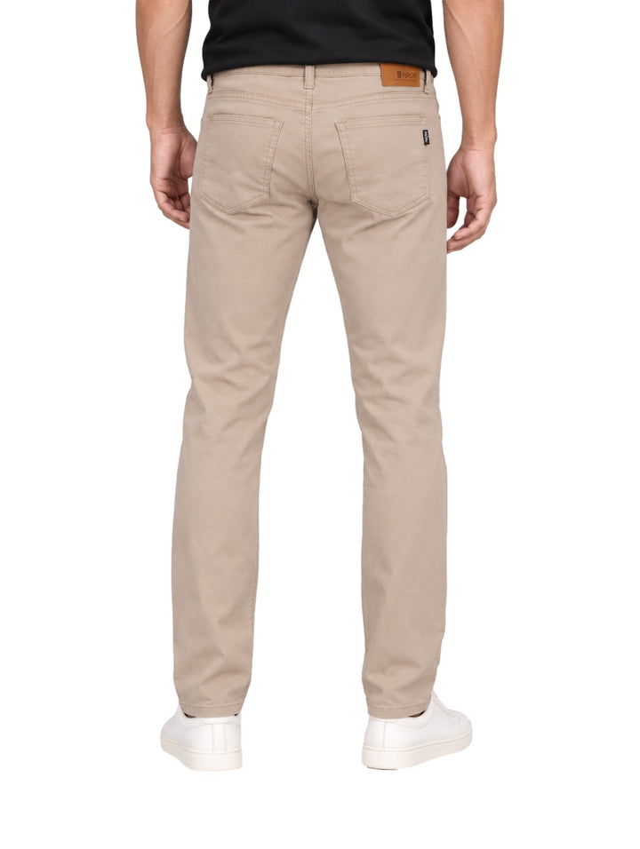 Hombre vistiendo un pantalón OGGI color khaki de corte recto y calzado blanco sobre fondo blanco.