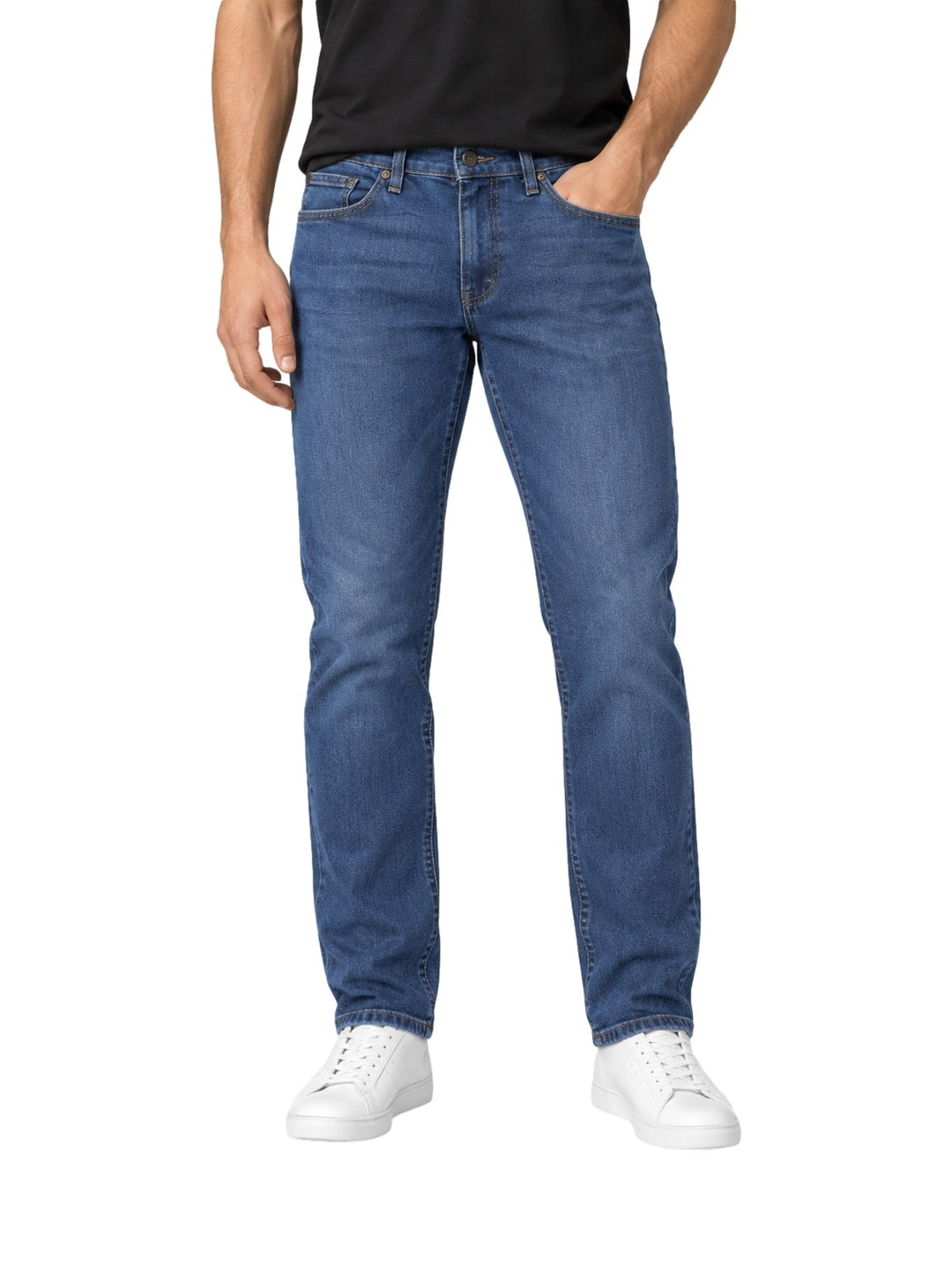 Hombre vistiendo jeans Lee de color azul con calzado blanco sobre fondo blanco.