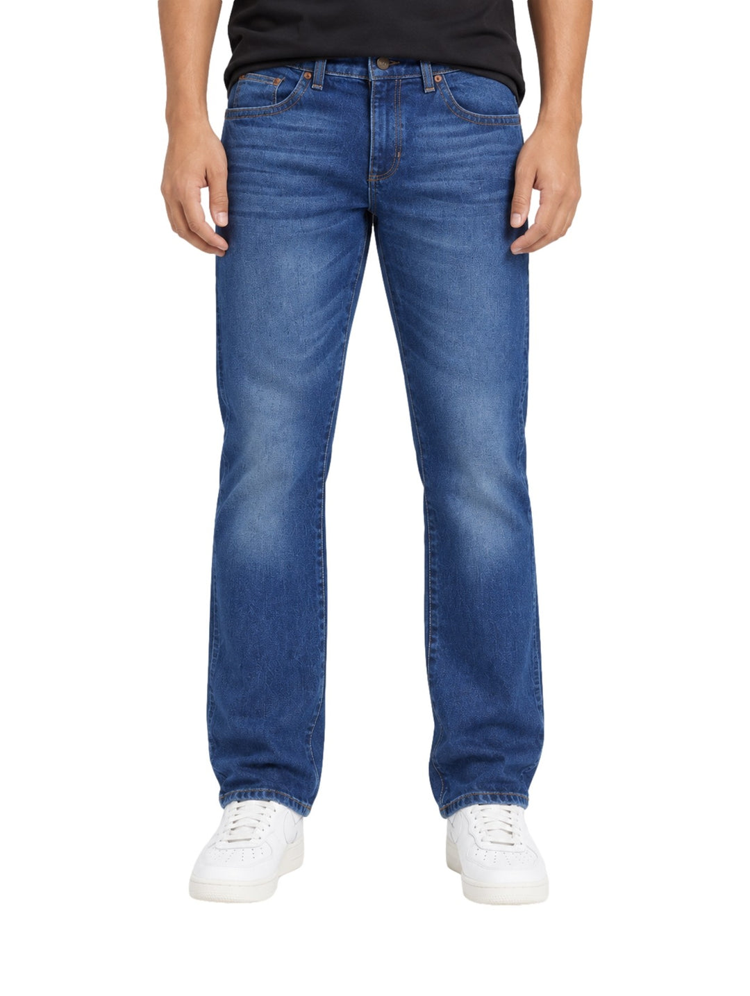 Hombre vistiendo jeans slim boot retro Wrangler en color azul con calzado blanco.
