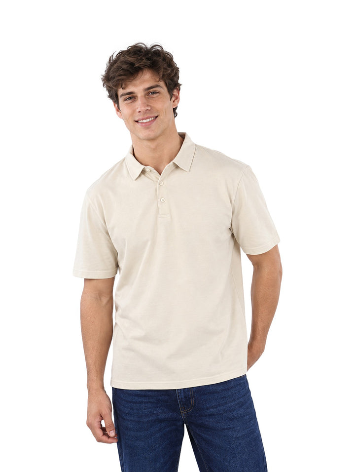 Hombre vistiendo una playera polo color beige de la marca Estivaneli con pantalones jeans azules.