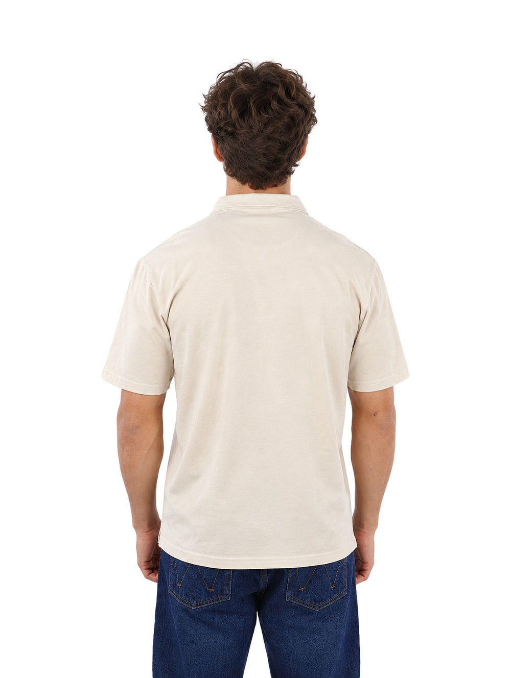 Hombre vistiendo una playera polo color beige de la marca Estivaneli con pantalones jeans azules.