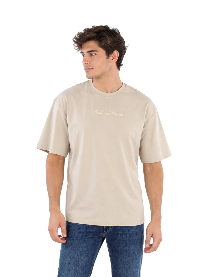 Hombre vistiendo playera color beige de manga corta y cuello redondo.