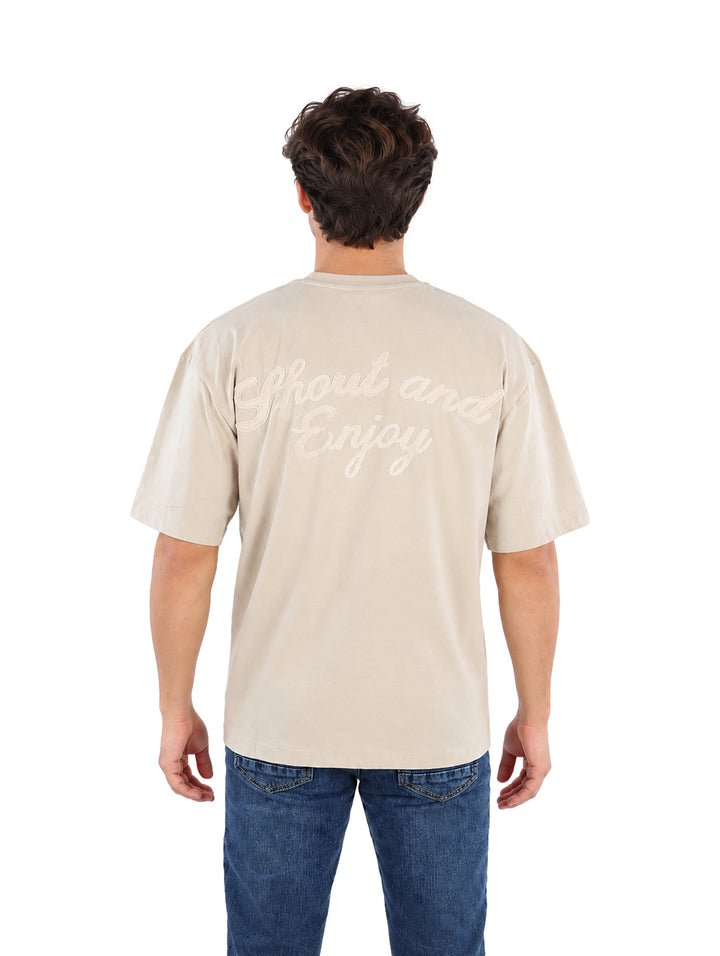 Hombre vistiendo playera color beige de manga corta y cuello redondo.