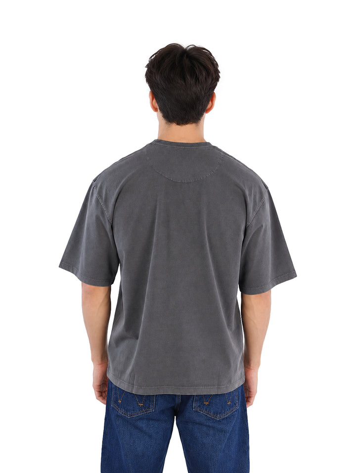 Hombre vistiendo playera de manga corta color gris oxford y pantalones azul oscuro.