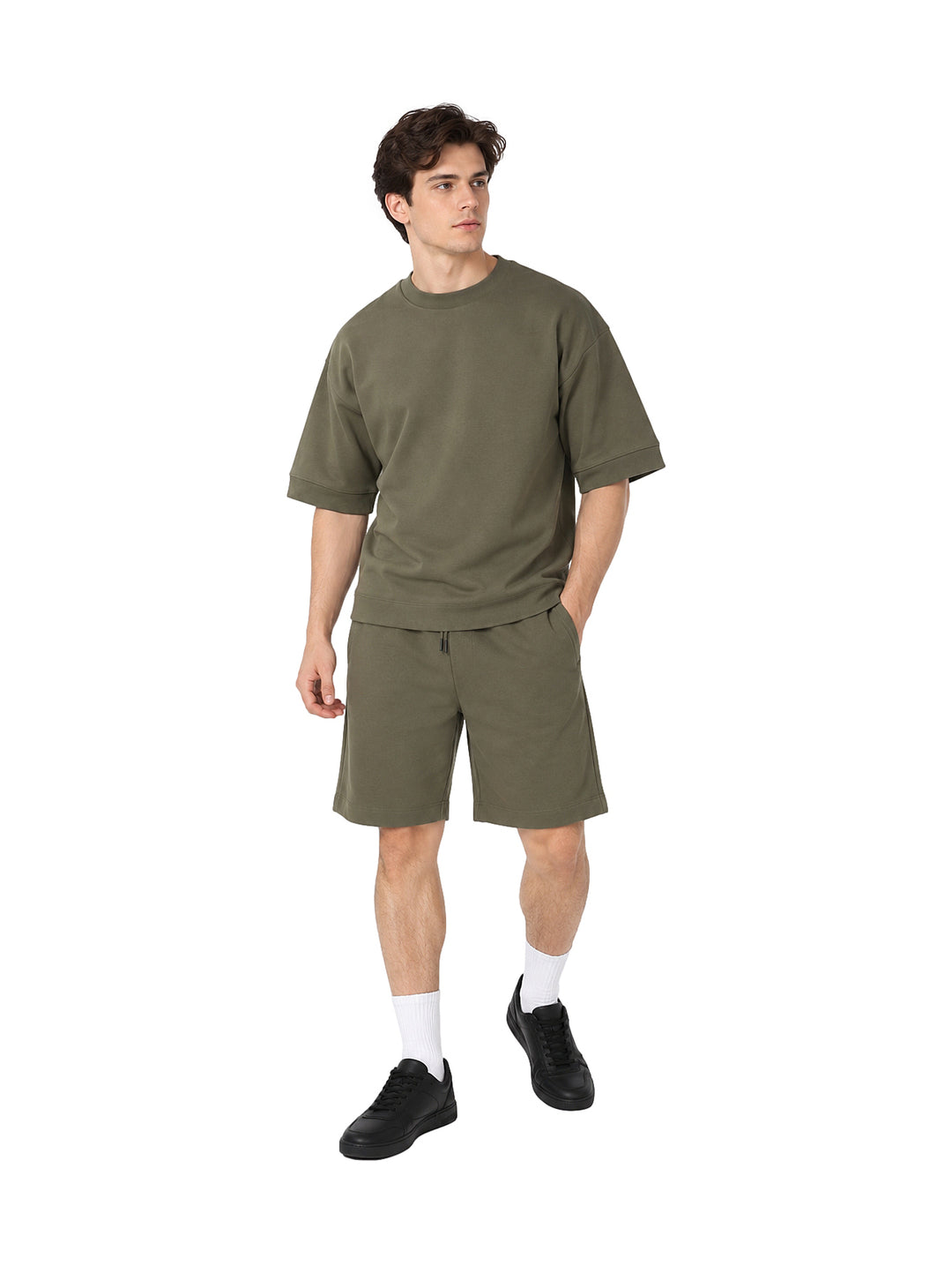Hombre vistiendo un conjunto de camiseta y shorts color olivo.