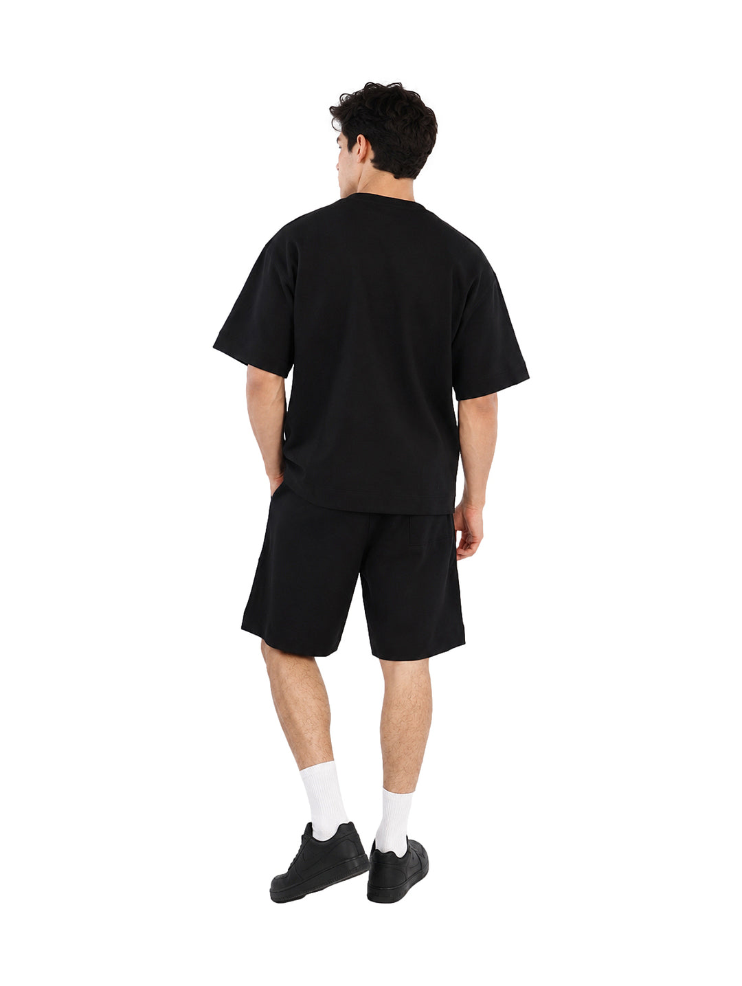 Hombre vistiendo un conjunto de camiseta y shorts color negro.