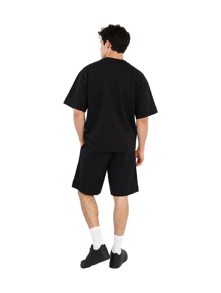 Hombre vistiendo un conjunto de camiseta y shorts color negro.