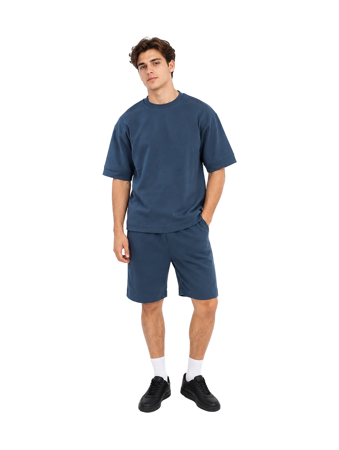 Hombre vistiendo un conjunto de camiseta y shorts color teal.