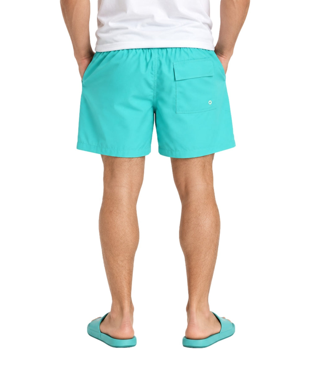 Hombre vistiendo un traje de baño corto color verde menta con cordón ajustable y sandalias a juego.