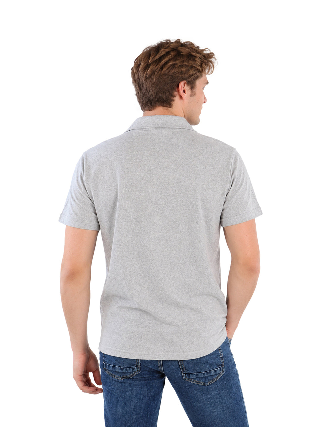 Hombre vistiendo una camisa gris de manga corta con botones y jeans azules sobre fondo blanco.