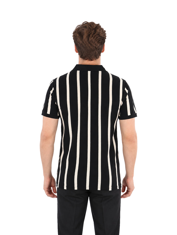 Hombre vistiendo playera de manga corta con rayas verticales negras y beige y cuello polo.
