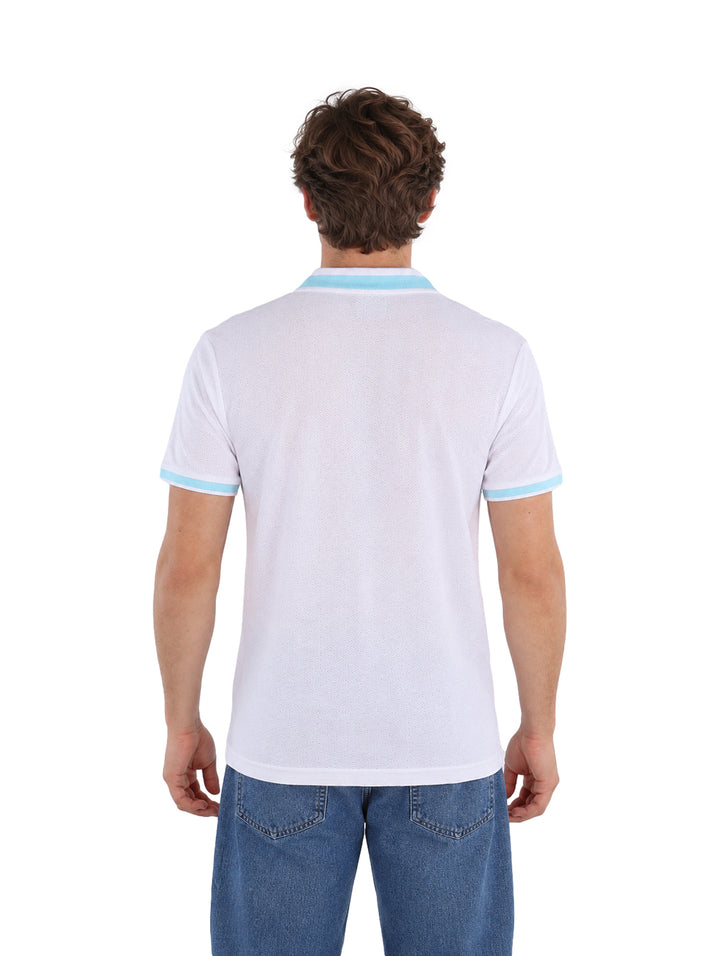 Hombre vistiendo playera polo blanca con detalles en color celeste en el cuello y mangas.