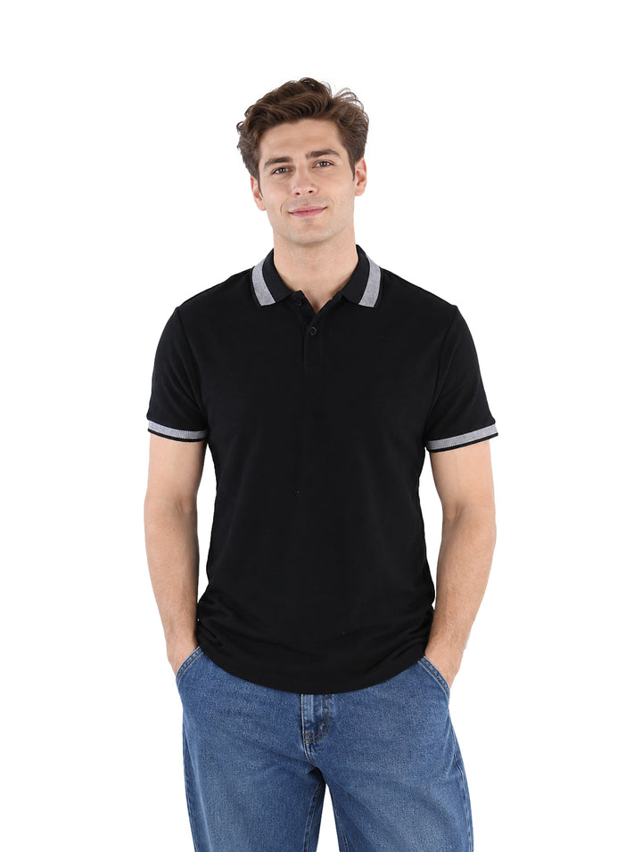 Hombre vistiendo playera polo color negro con detalles grises en el cuello y los bordes de las mangas.