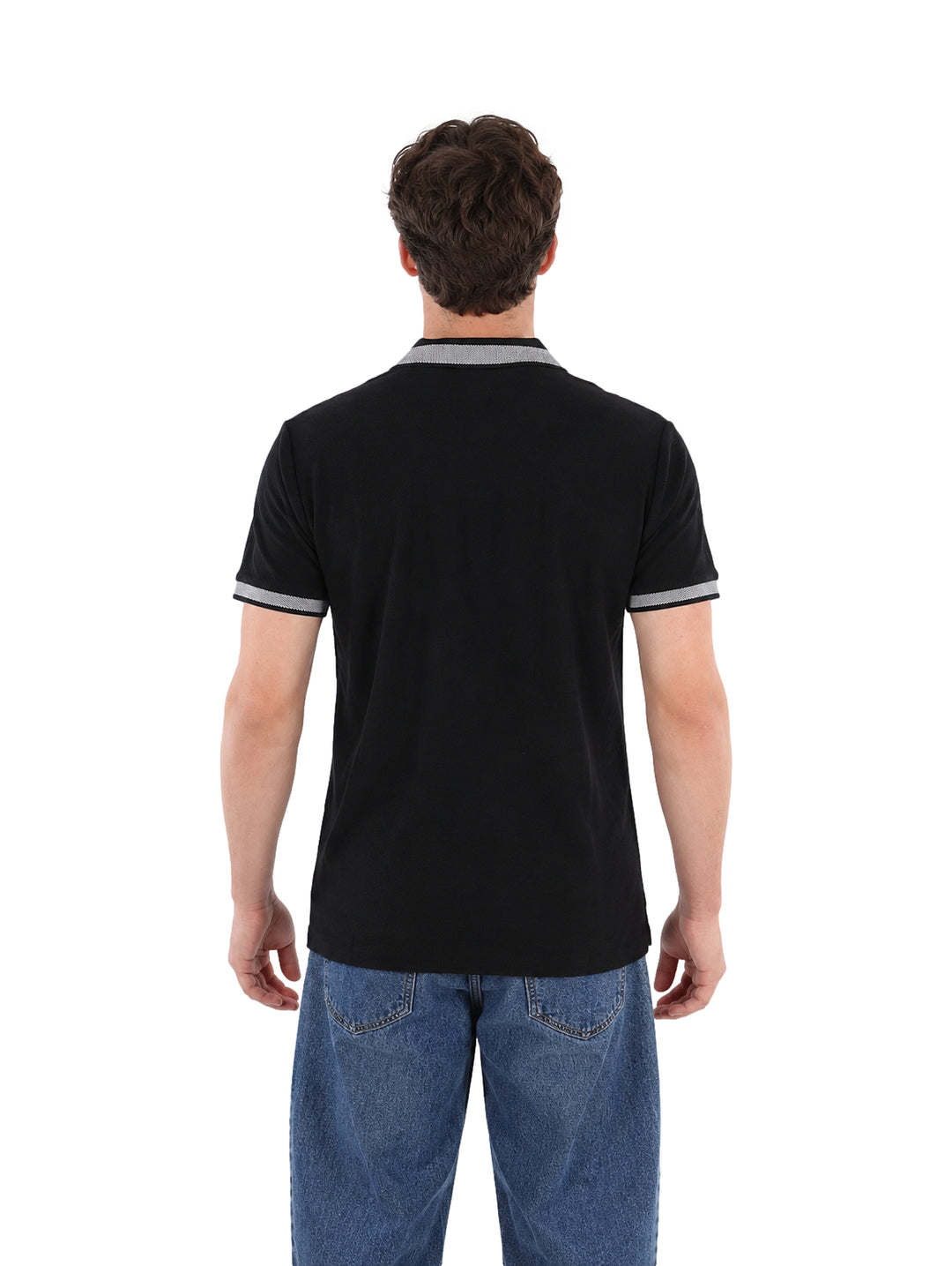 Hombre vistiendo playera polo color negro con detalles grises en el cuello y los bordes de las mangas.