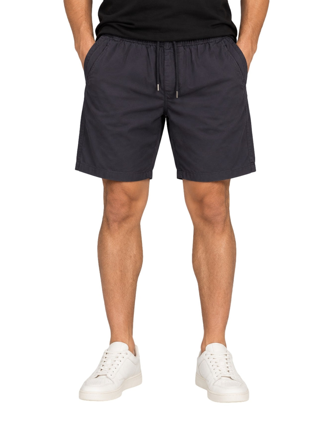 Hombre vistiendo bermuda American Fly color marino con cintura elástica y cordón, combinada con tenis blancos.