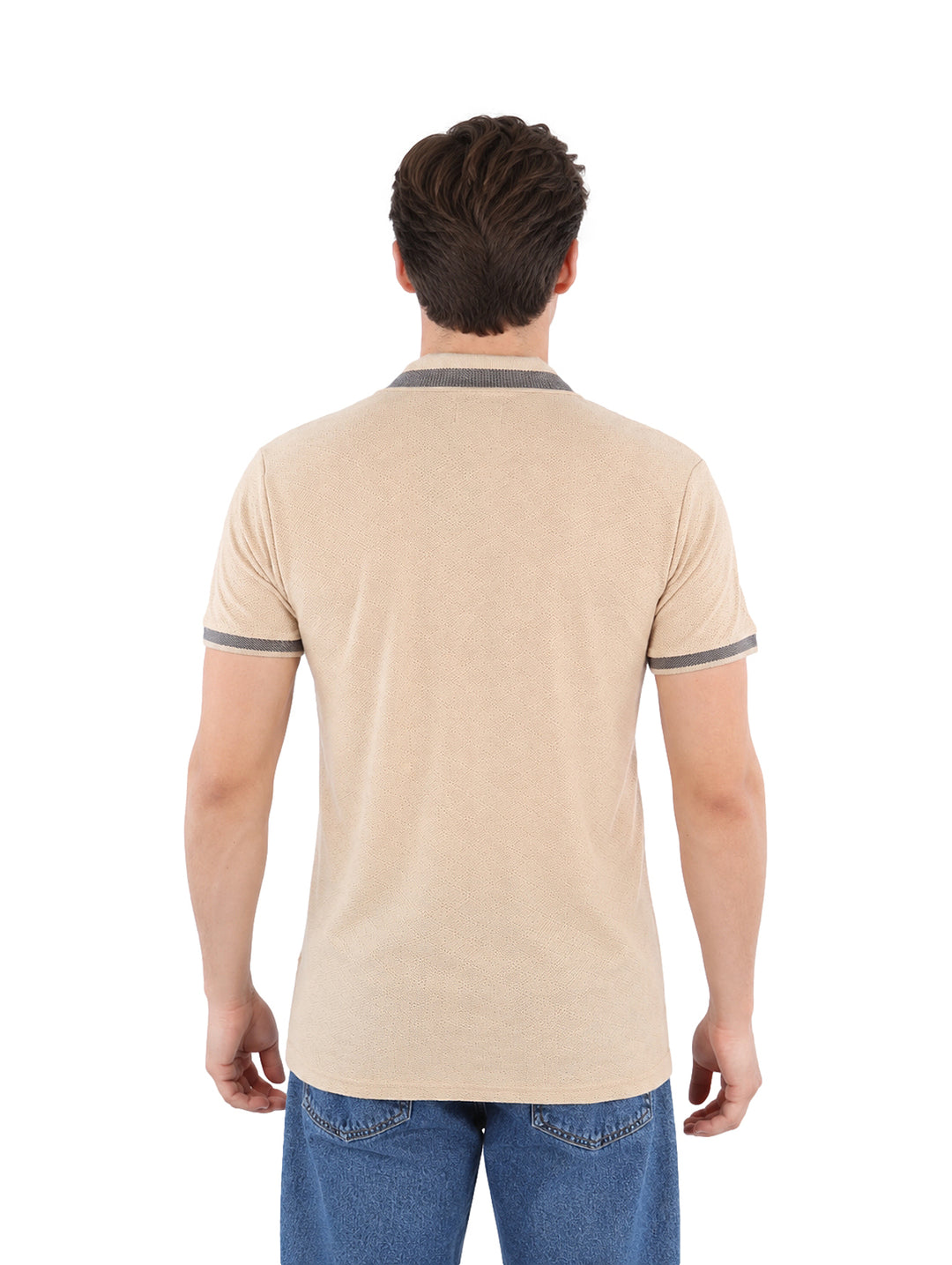 Hombre vistiendo playera polo color beige con detalles grises en el cuello y los puños.