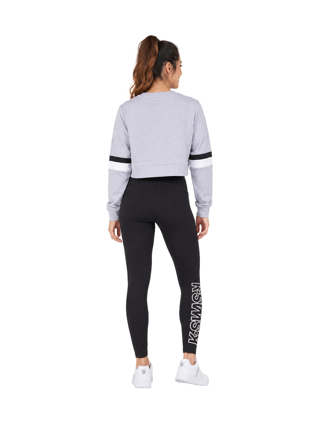 Conjunto deportivo K-Swiss con sudadera corta gris y leggings negros.