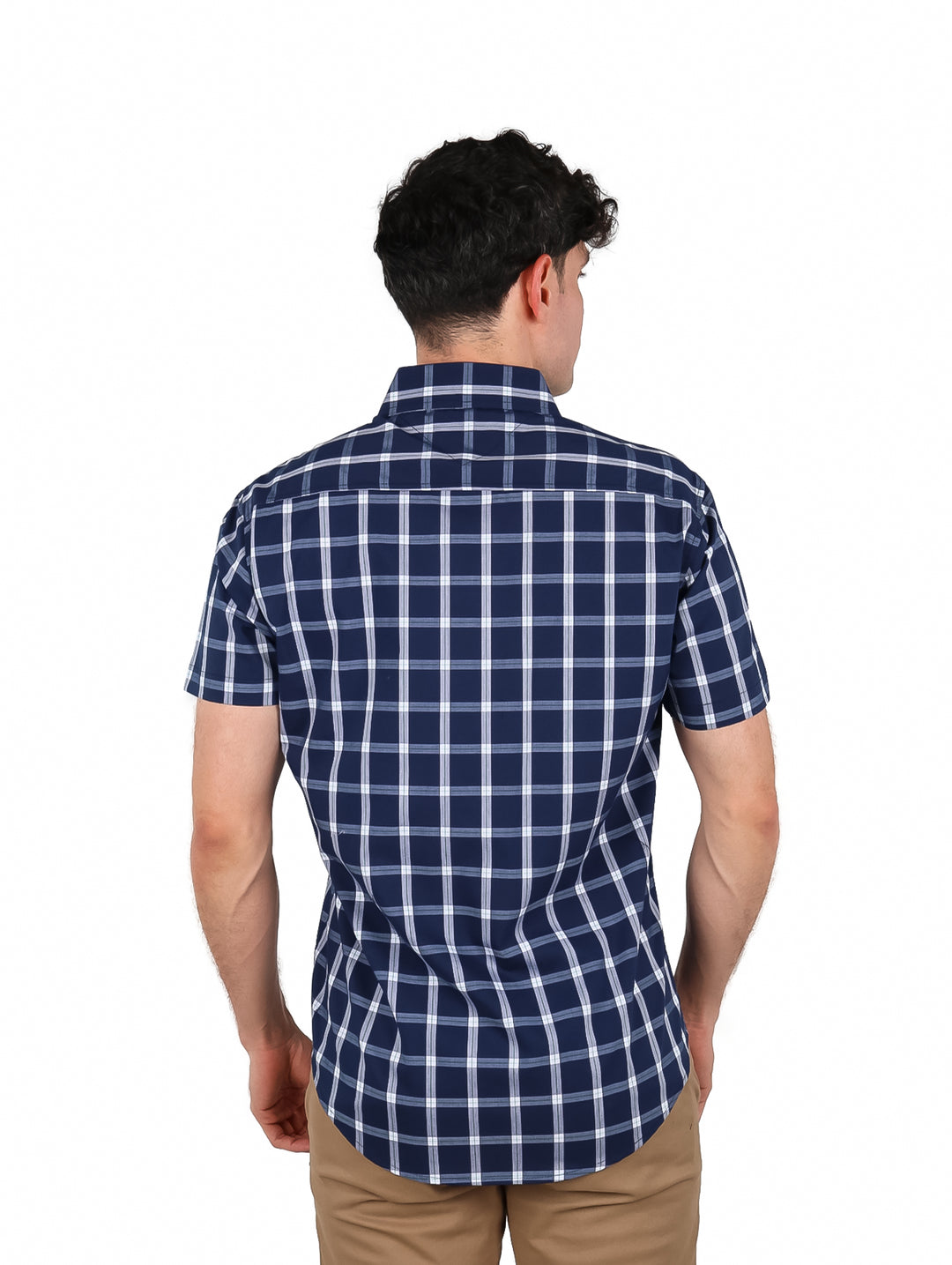 Hombre vistiendo camisa de manga corta con patrón de cuadros en color azul marino y blanco.
