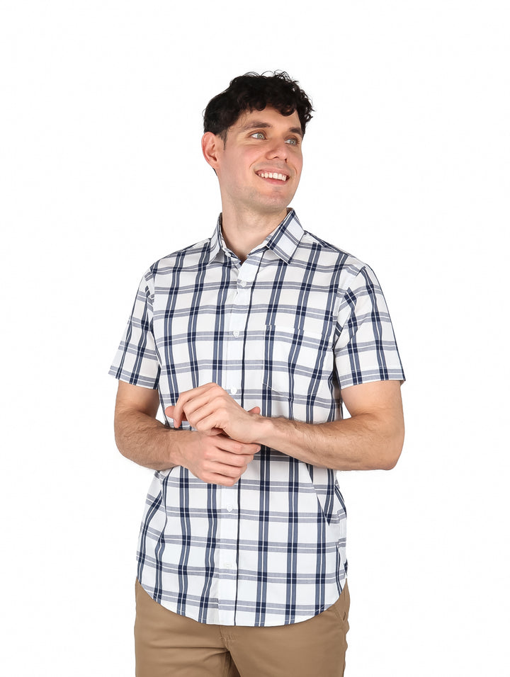 Hombre vistiendo camisa de manga corta con estampado de cuadros en color blanco y negro.