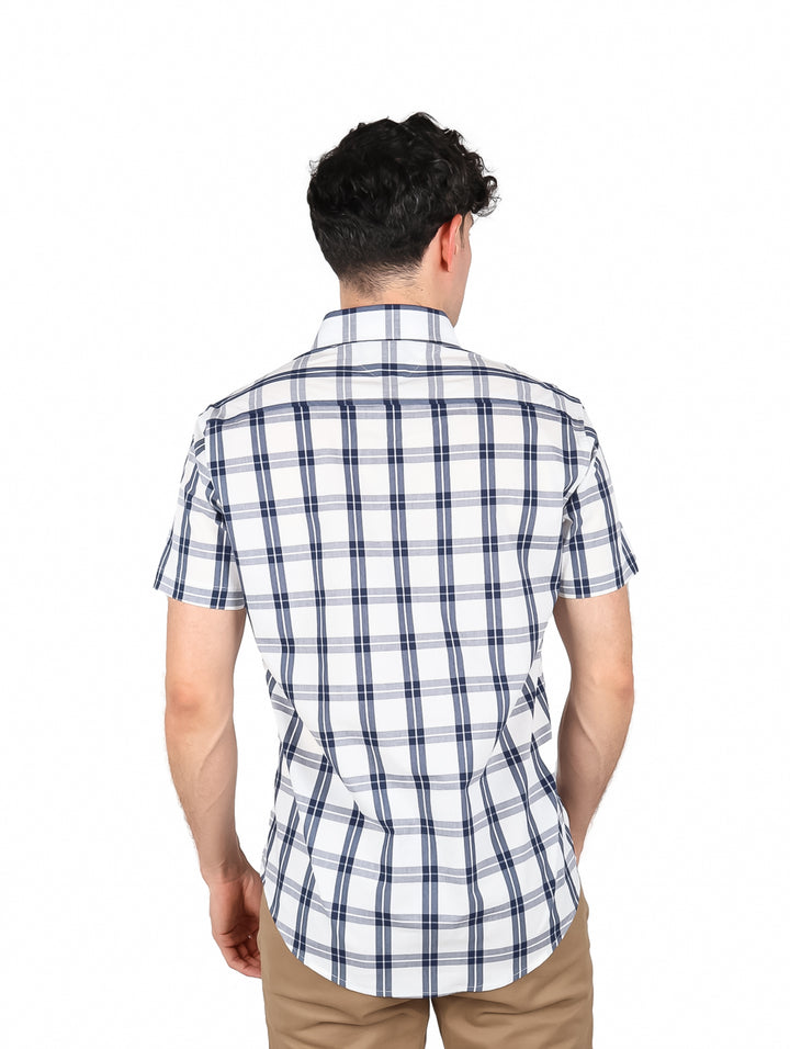 Hombre vistiendo camisa de manga corta con estampado de cuadros en color blanco y negro.